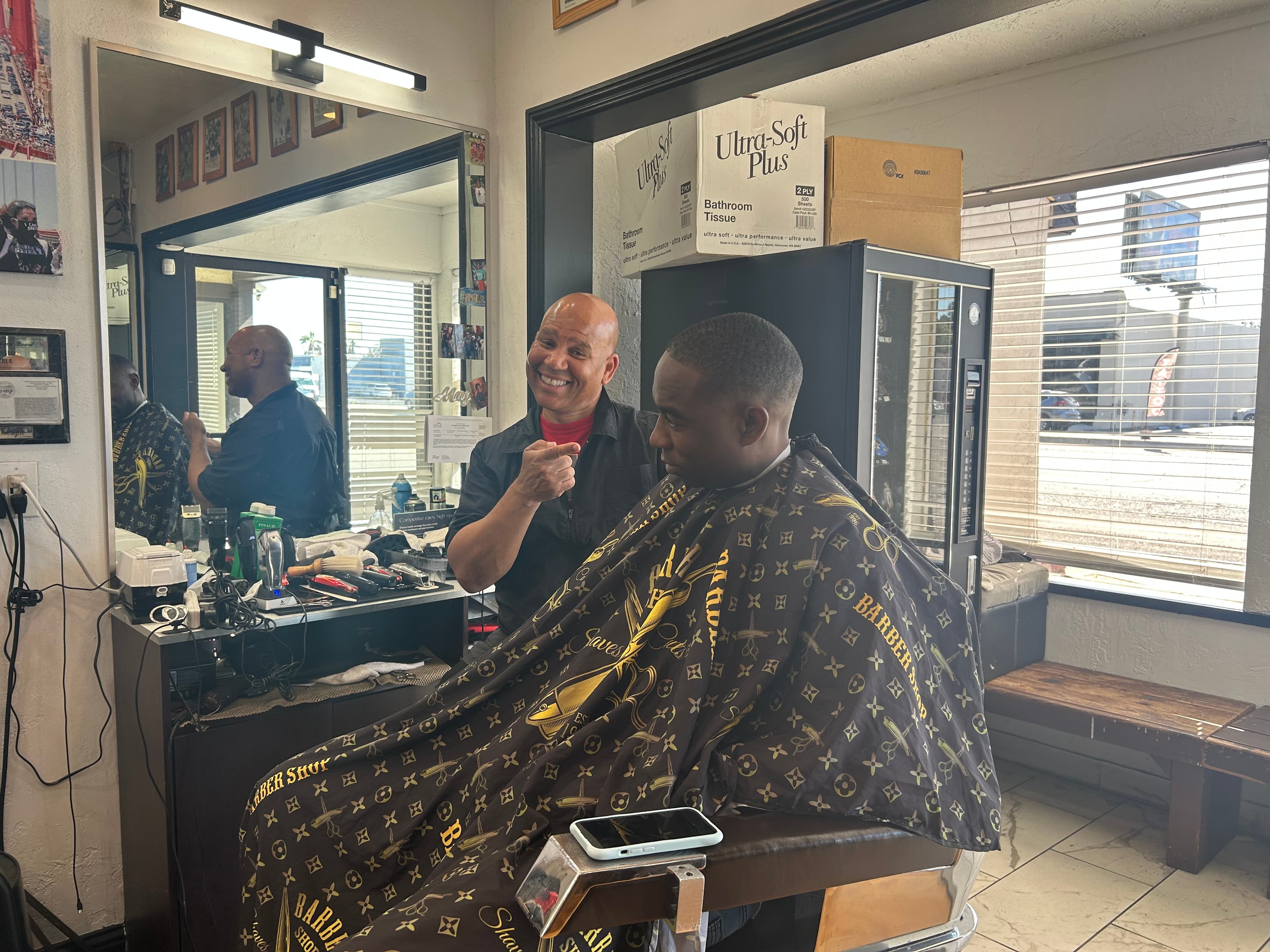 Magic laughing with a client mid-cut at Style Masters Barbershop